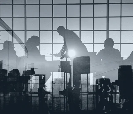 Silhouette of institutional corporate partners collaborating in a modern office boardroom overlooking a city view.