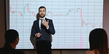 Professional market analyst presenting current crypto market data trends on a large digital projection screen.